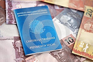 Brazilian work card and social security blue book and reais money bills