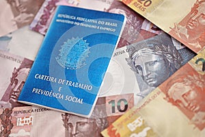 Brazilian work card and social security blue book and reais money bills
