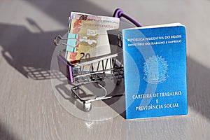 Brazilian work card and social security blue book and reais money bills in shopping cart
