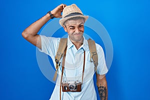 Brazilian young man holding vintage camera confuse and wonder about question