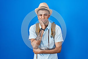 Brazilian young man holding vintage camera thinking looking tired and bored with depression problems with crossed arms