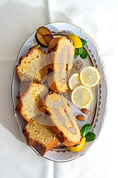 Brazo de gitano, typical spanish swiss roll filled with pastry cream of coffee and lemon cake. White natural linen background. Alm