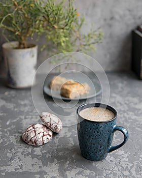 Breacfast with blue mug of coffee or cappuccino with red velvet cookies and two pieces of almond cake. Selective focuse