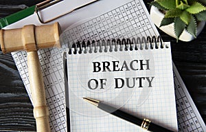 BREACH OF DUTY - words on a white sheet on the background of a judge\'s gavel, a cactus and a pen
