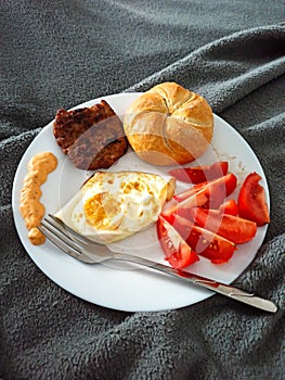 Breackfast eggs meat tomatoes bread