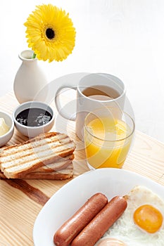 Breackfast with tea, toasts, scrambled eggs, sausages and flower macro photo