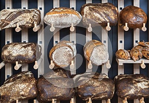 Bread assortments on wooden shelves. Bakery context