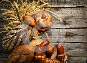 Bread. Bakery Bread border on a Wooden Table. Assortment Various Bread and Sheaf of Wheat Ears close up