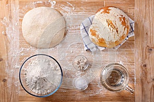 Bread and basic ingredients on pastry board, top view.