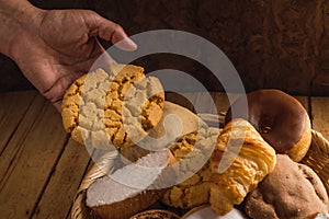 Bread basket, typical of the peoples of Mexico. With one hand taking a polvoron. 2 photo