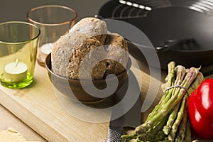 Bread on Bowl on Board with Glasses and Knife