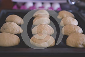 Bread buns dough shaped and ready for baking in the oven