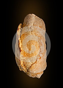 Bread buns top view on black background. Close-up of a single whole bread roll isolated on black. Flat lay.