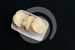 Bread and butter on white dish.