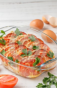 Bread casserole with sausage, cheese, tomatoes, eggs and parsley