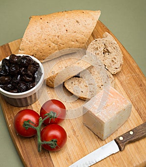 Bread and cheese/Delicious organic cream milk cheese, olives and home-made bread and ripe tomatoes on wooden board.