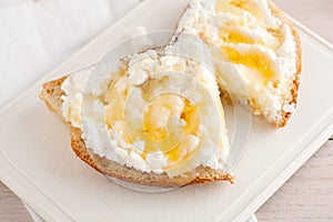 Bread with cheese and honey on white chopping