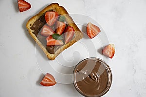 Bread with chocolate paste, brown  paste  strawberries on a light background
