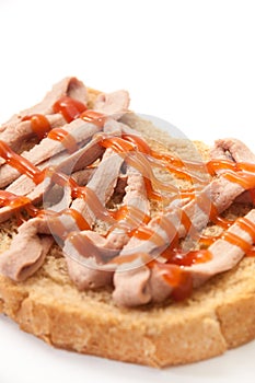 Bread coated with pate and ketchup