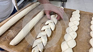 Professional baker`s hand gathering the dough and creating the loaves of bread. Bread concept, bakery, baker, industry, business