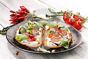 Bread with cream cheese and tomato for lunch table. Sharing antipasti on party or summer picnic time over wooden rustic background