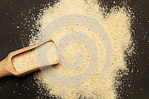 Bread crumbs on a wooden scoop and on a black background