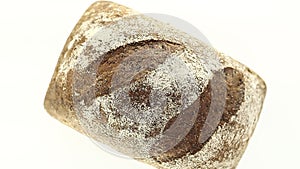 Bread dark whole, with flour, rotates counterclockwise, turning, top view, close up