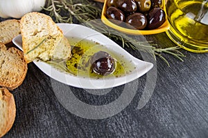 The bread dipped in olive oil with olive. Greek olive oil bread dip. Italian Bread with Oil for Dipping with Herbs & Spices.