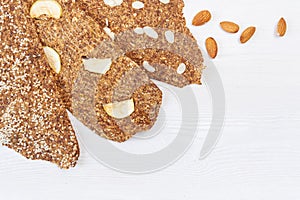 Bread with flaxseeds and almonds on a white wooden background. Useful dietary raw bread vegan breakfast without yeast