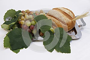 Bread and grapes with leaves on tray at Catholic Mass