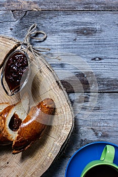 Bread and jam on the scratched wooden cutting board