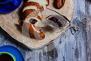 Bread and jam on the scratched wooden cutting board