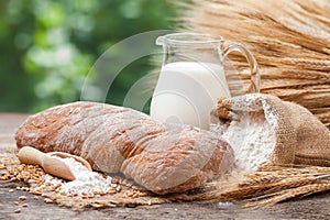 Bread, jug of milk, sack with flour and sheaf of wheat