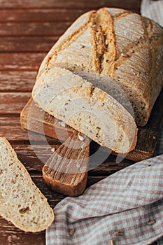 Bread loaf on rustic wooden cutting board and napkin