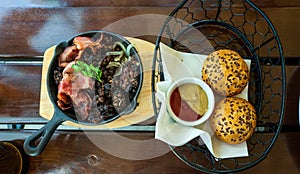 Bread loaf with sauce next to Kaszanka, Polish delicacy made from pork meat often also organ meat, barley or buckwheat and pigÃ¢â¬â¢s photo