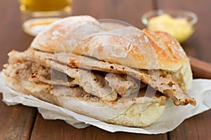 Bread with meat on brown background and glass of beer photo