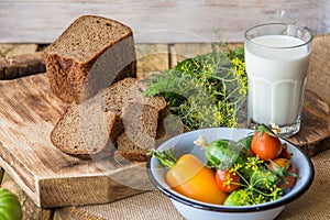 Bread, milk and vegetables on a wooden background in rustic style