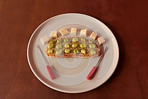 Bread, oil, broad beans and cheese in a white dish.