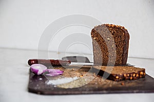 Bread and onions on a cutting board isolated salt