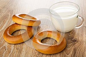 Bread rings baranka, cup with milk on wooden table photo