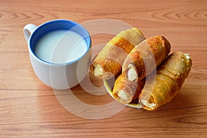 Bread roll filling cream and milk cup on table