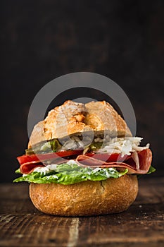 Bread rolls topped with salami, salad, tomatoes