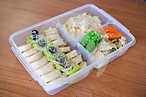 Bread salad roll wrap sandwich with berry, lettuce, .kiwi ,bananas and bean ,.chicken breast with rice on the rice box