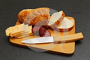 Bread, salami and cheese on the wooden plate photo