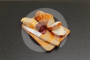Bread, salami and cheese on the wooden plate photo