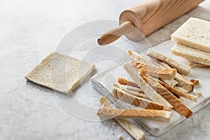 Bread slice thinned with roller pin and bread crusts on table