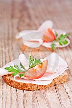 Bread with sliced ham, fresh tomatoes and parsley