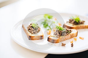 bread slices with tapenade spread on white plate