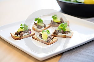 bread slices with tapenade spread on white plate