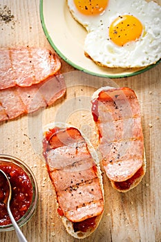 Bread slices with tomato relish, turkey rasher and fried egg